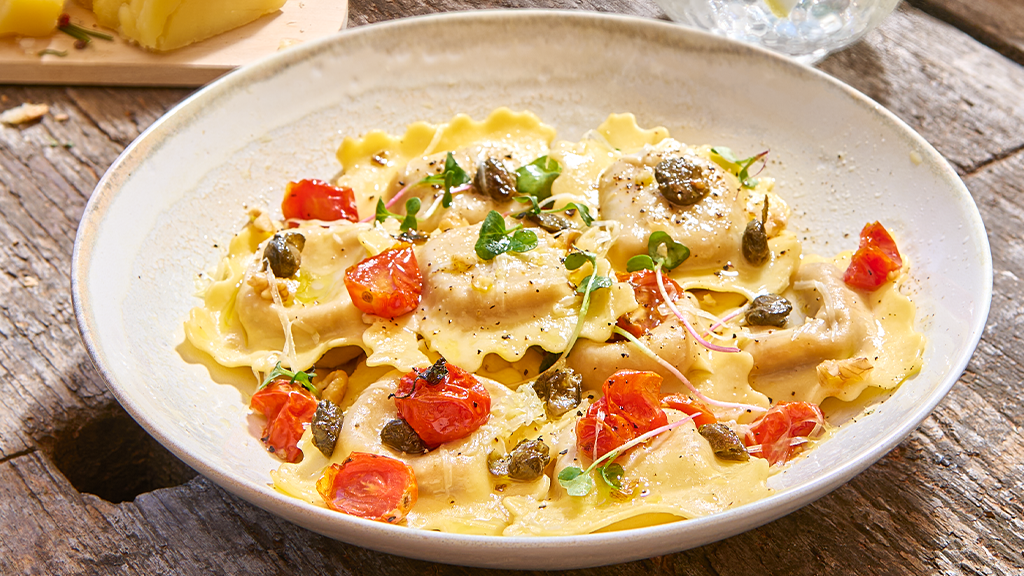 Image of RAVIOLONES CAPRESSE CON TOMATITOS SALTEADOS, ACEITE VERDE Y GREMOLATTA DE PISTACHOS