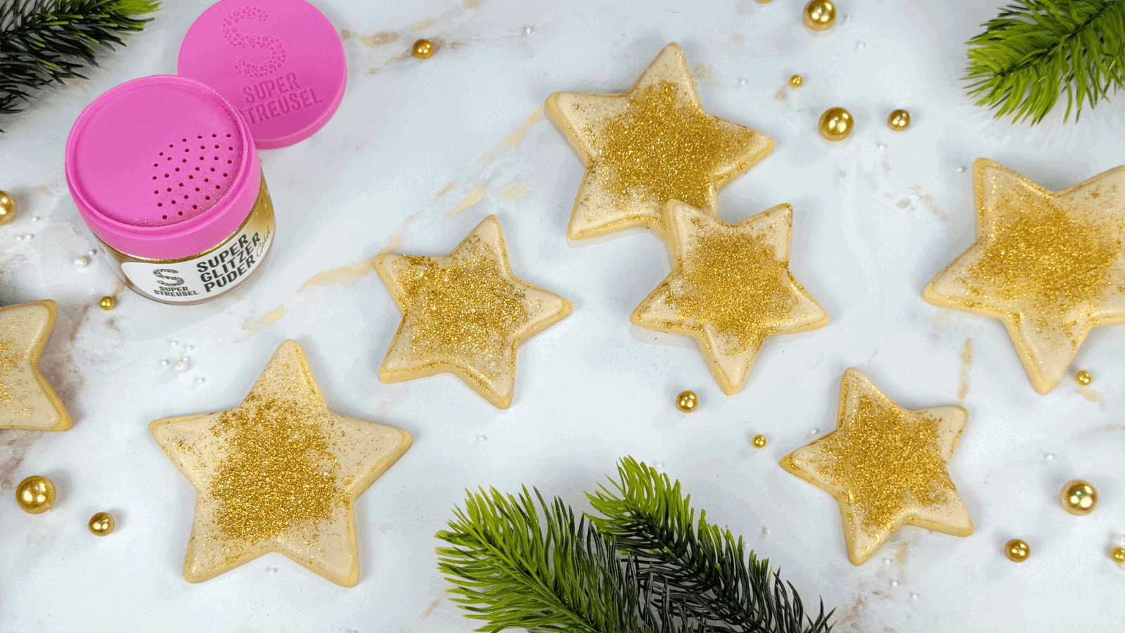 Zimtige Sternplätzchen in verschiedenen Größen, mit SuperDrip Zimt glasiert und mit goldenem SuperGlitzerPuder bestäubt. Weihnachtliche Zimtsterne mit goldener Glitzer-Deko.