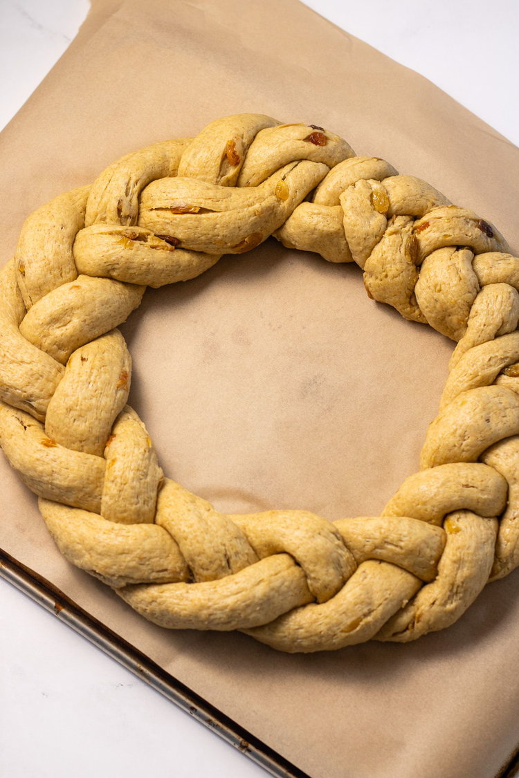 Image of Place the wreath on parchment paper on a baking sheet....