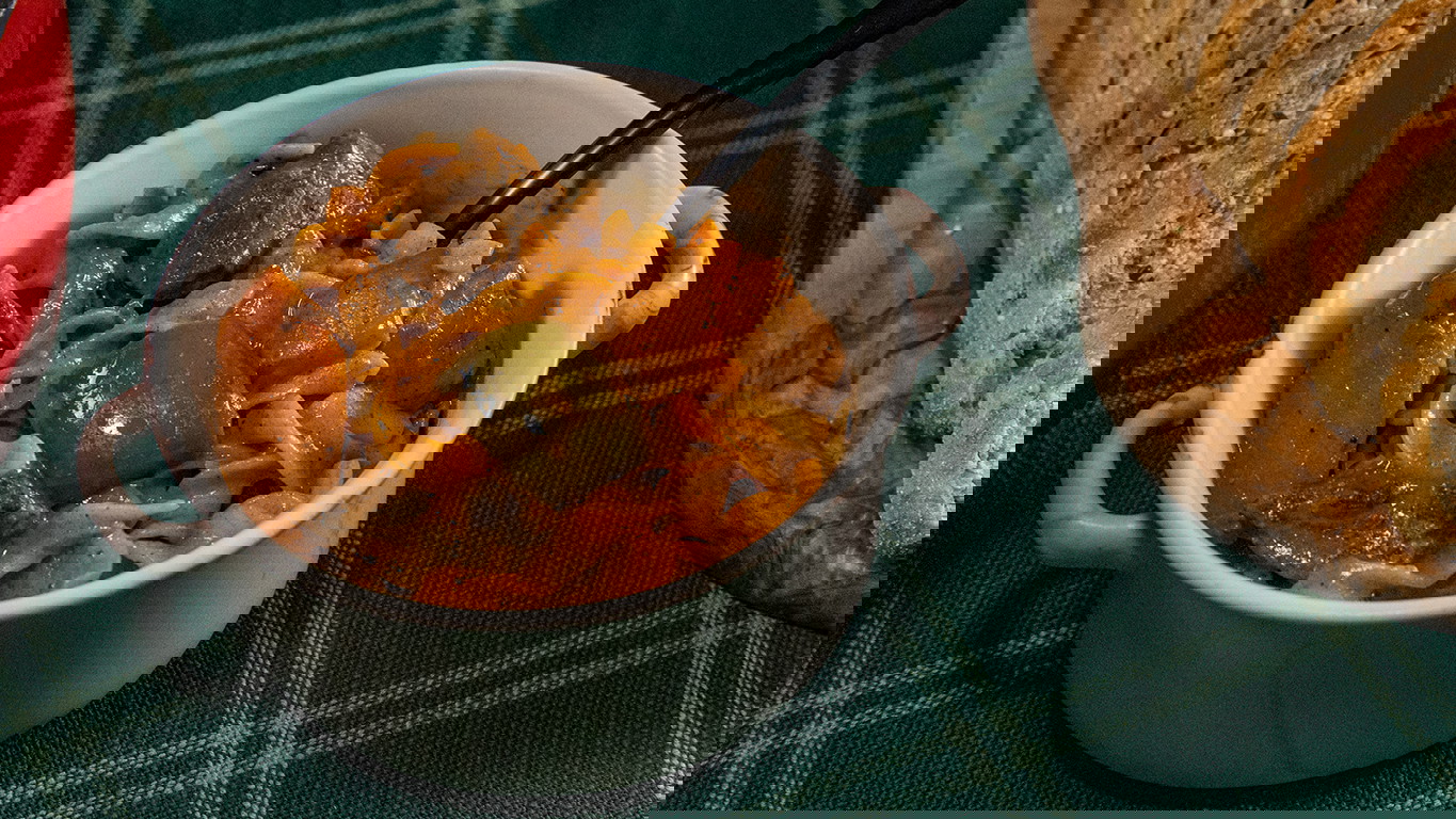 A ramekin of creamy Beef goulash with egg noddles, chopped green pepper, onion, and carrot with chunks of tender Halal beef, all mixed in with a creamy and zest sauce. Served with whole grain bread.