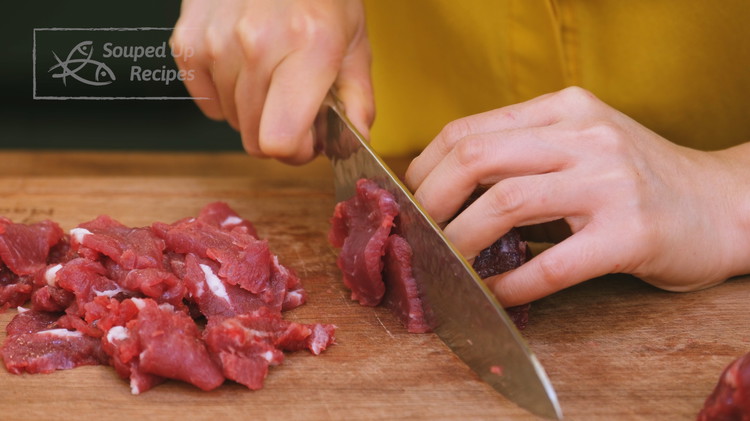 Image of Cut the beef into a few big chunks. Then slice the beef into 1/8 of an inch thick slices. Recommend using flank steak, ribeye, and sirloin. 