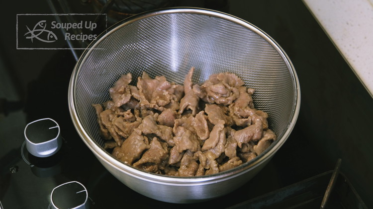 Image of As soon as the beef slices just change color, take them out immediately and drain them well in a sieve. This step is crucial—good draining is what keeps the final dish from being greasy. Don’t toss out the oil. You...
