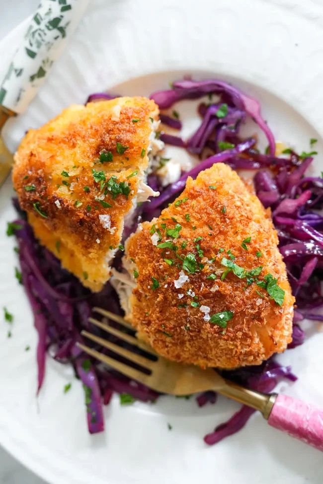 Herby Chicken stuffed with ghee sitting on cabbage.