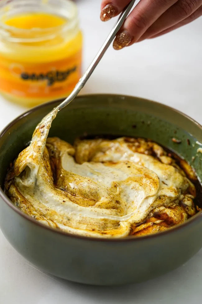 spoon running through spiced ghee yogurt