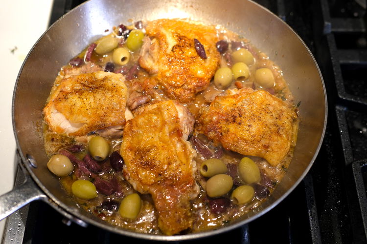 Image of Put olives between the chicken thighs.