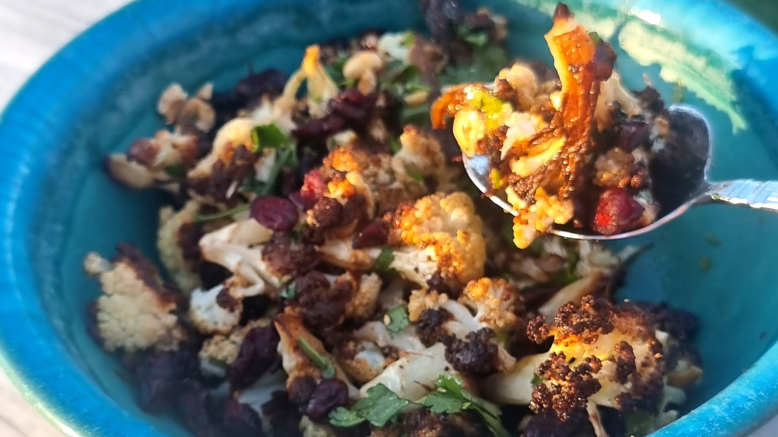 Roast Cauliflower Salad with spiced black garlic dressing in a bowl