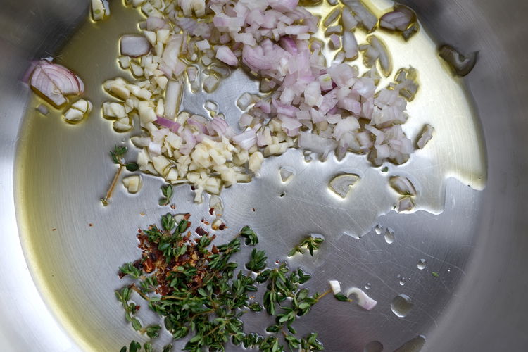 Image of Add olive oil to pan with herbs and crushed red...