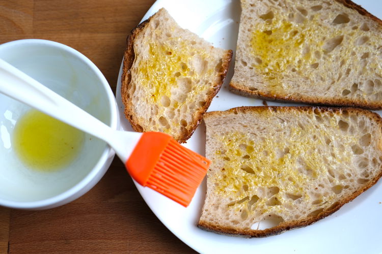 Image of Prepare bread for grilling by brushing with olive oil and...