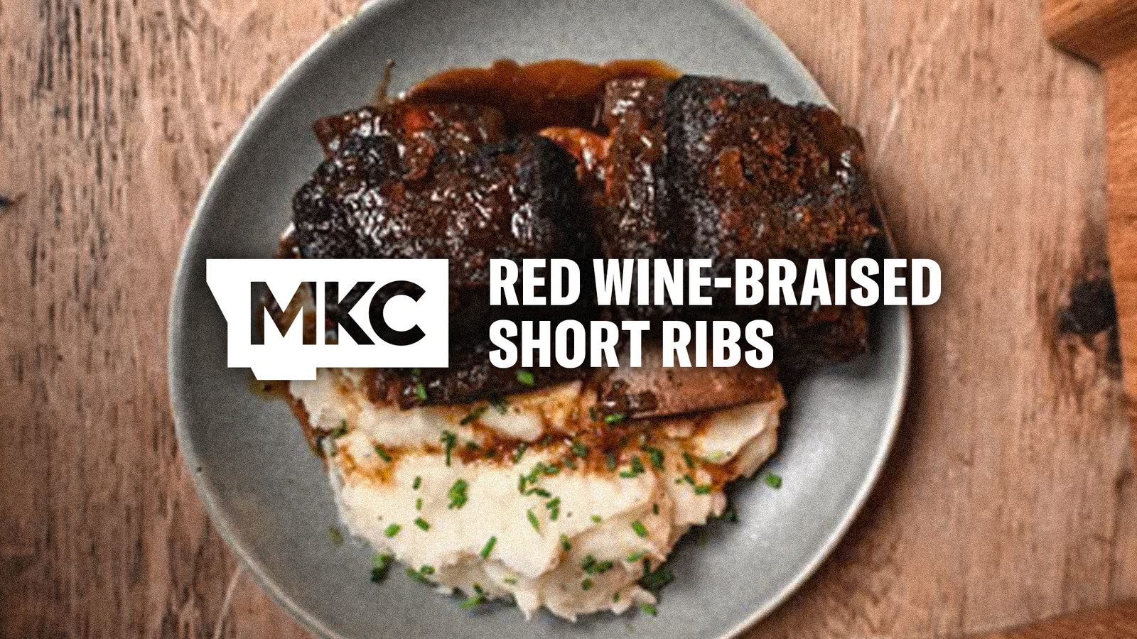 Red wine-braised short ribs with mashed potatoes on a dinner plate.