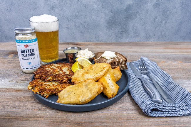 Plate of golden beer battered bluegill filets seasoned with PS Seasoning Butter Blizzard, served with crispy hash browns, rye bread, lemon wedges, spicy dill tartar sauce, and a cold beer. Classic fish fry meal with garlic-butter flavor and crispy texture.
