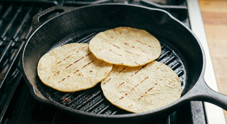 Image of While the steak rests, warm the corn tortillas on the...