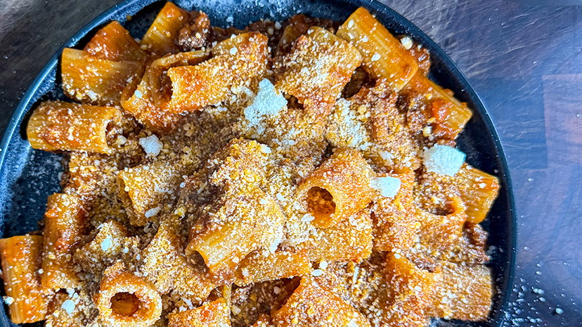 Weeknight Bolognese on a blue plate with a blue background