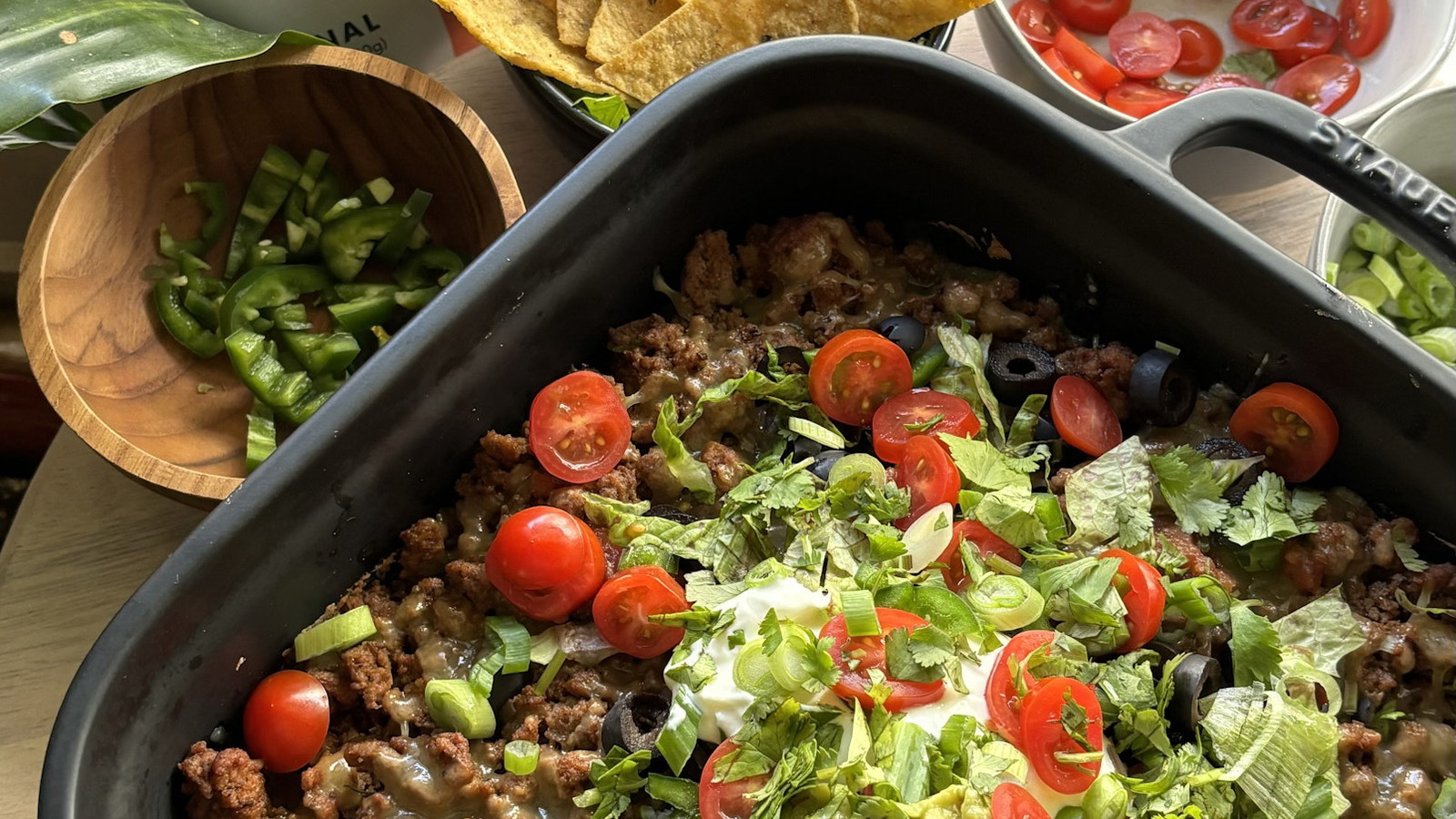Savory, protein-packed layer of seasoned beef and melted cheddar, topped with a mountain of fresh garden veggies and cool guacamole, served with MASA Chips.
