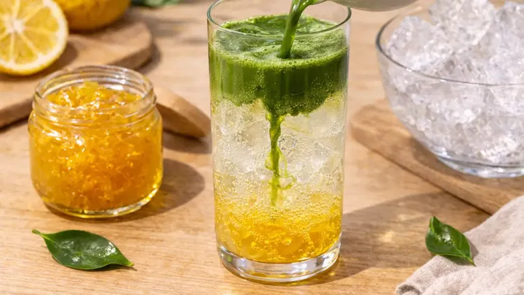 Image of Slowly pour the whisked matcha over the soda mixture to...