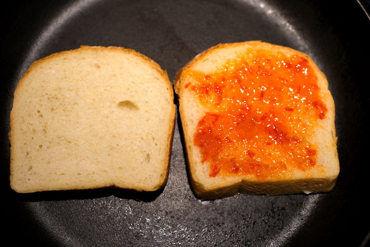 Image of Spoon jam onto one of the bread slices and use...