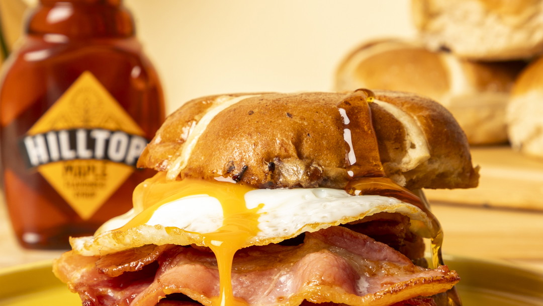 Image of Hot cross bun bacon sandwich with maple syrup