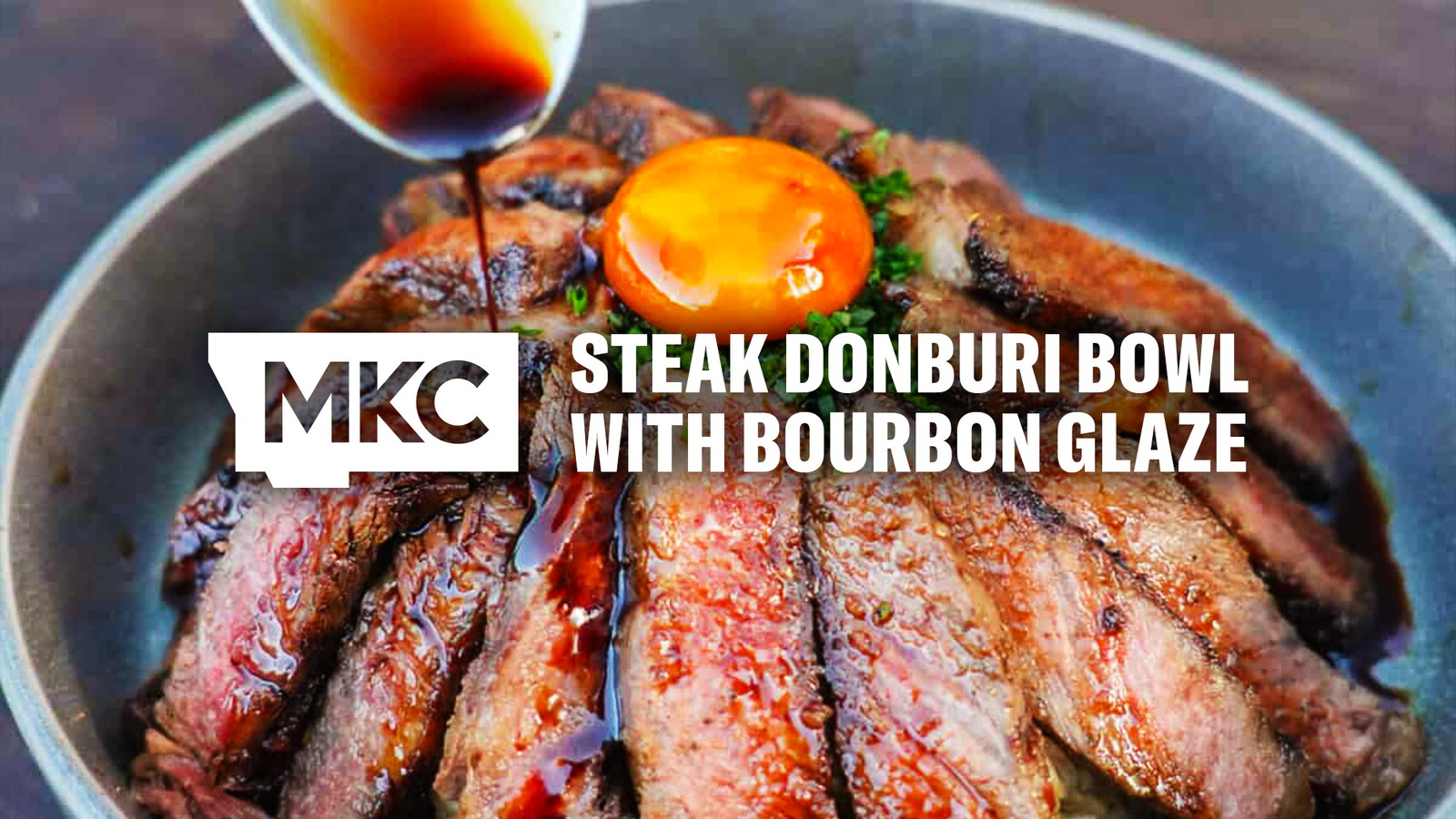 Sliced steak topped with egg yolk and garnish with a bourbon glaze being spooned on top for a steak donburi dish.