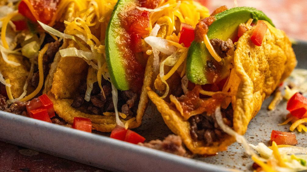 Tacos crujientes de ternera con queso, salsa y aguacate