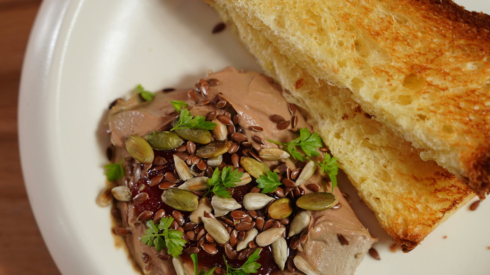 toasted bread with a pate on the side topped with nuts.