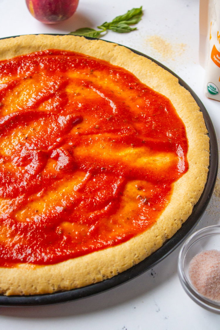 Image of Spread the pizza sauce on top. 