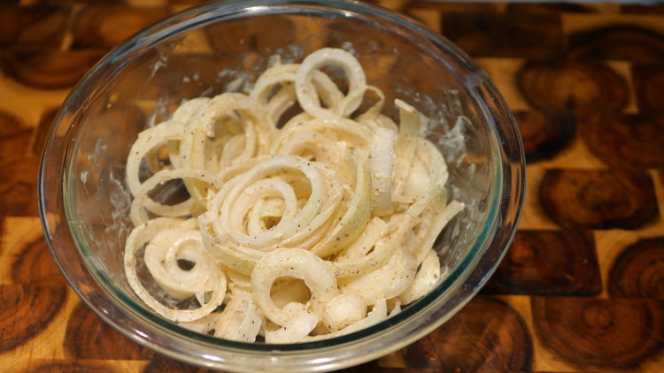 Image of In a bowl, toss the sliced onions with: salt, black...