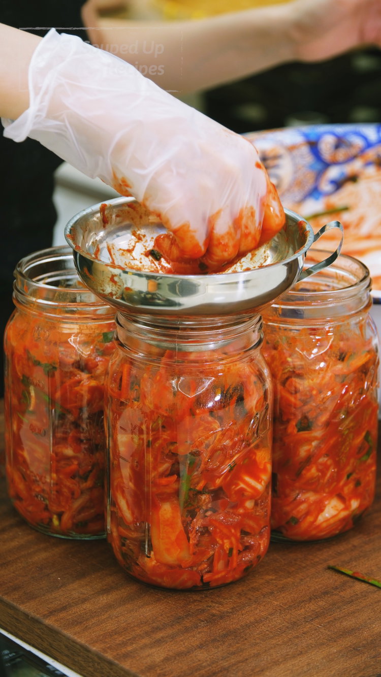 Image of Transfer the kimchi to clean jars or containers, pressing down...