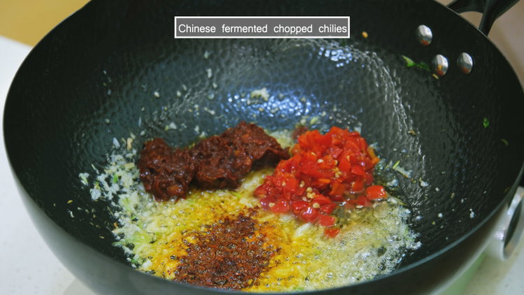 Image of Add chili flakes, doubanjiang, and fermented chilies. Stir until the...