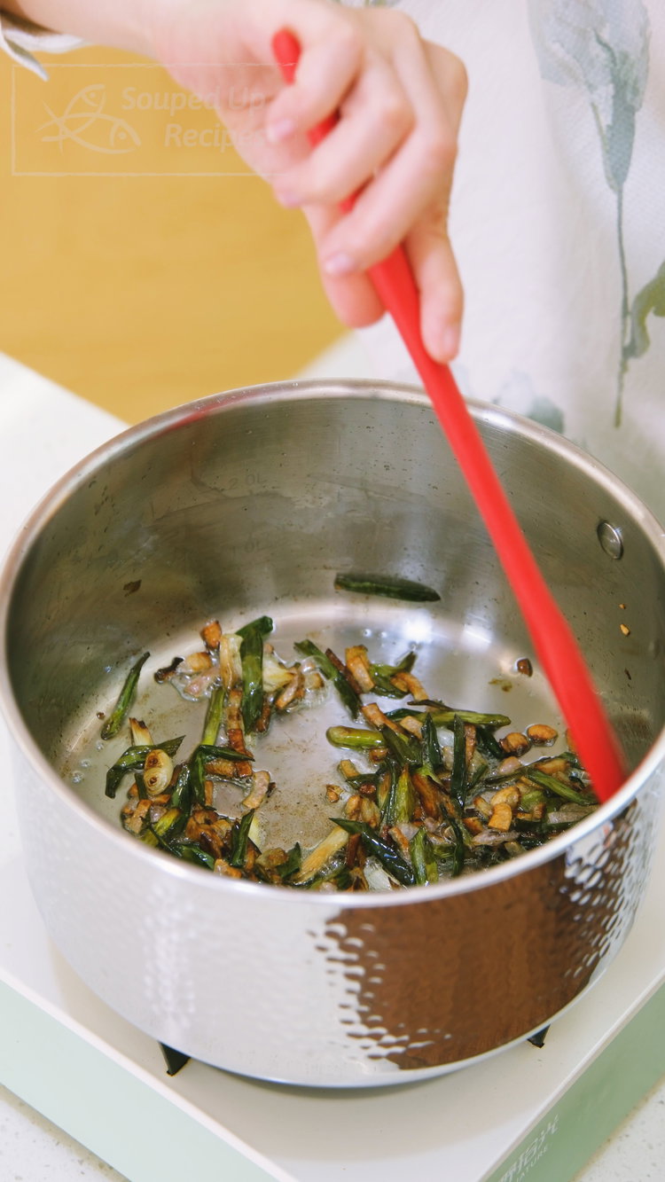 Image of Add the scallions, shallots, and oil to a pot. Cook...