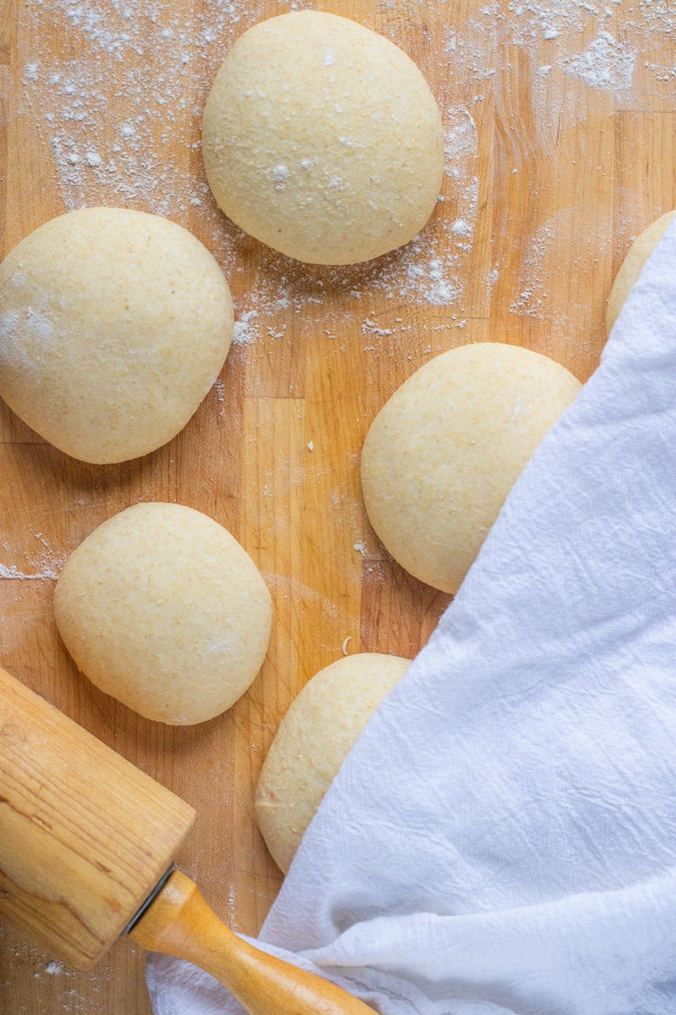 Image of Divide the dough into 10 and roll into balls. Let...