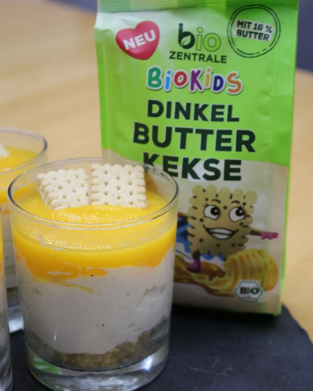 Cheesecake im Glas mit Butterkeksen und Mango