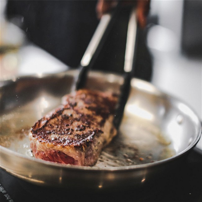 New York Steak Cooking in Stainless Steel Pan
