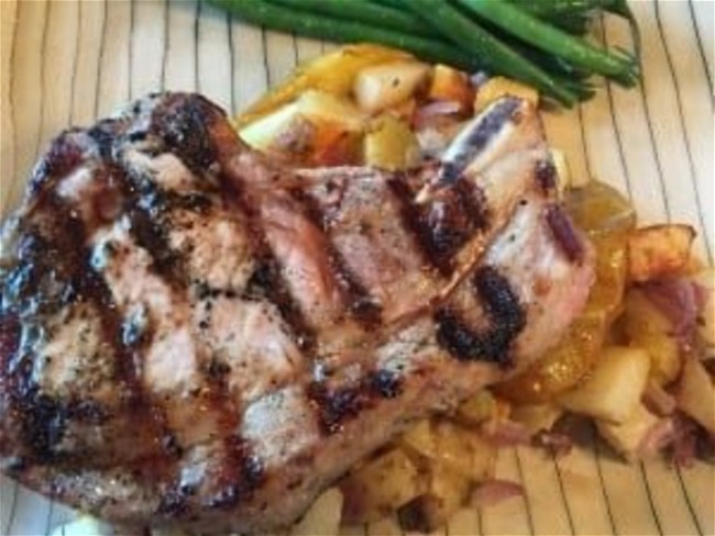 Image of Cider-Cured Pork Chops on a bed of Caramelized Apples and Onions